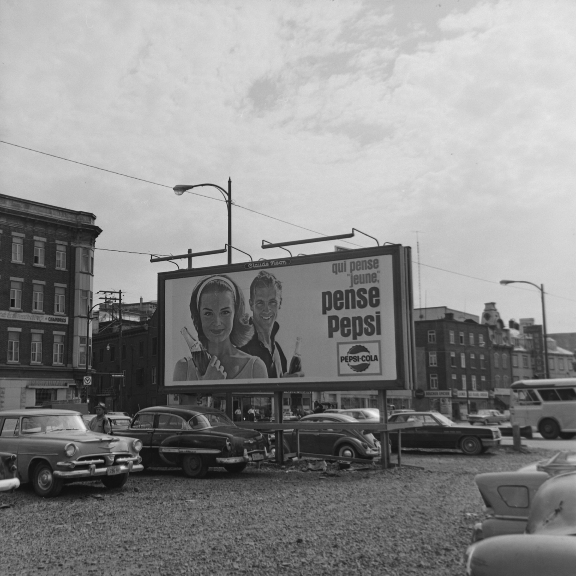 Il s'agit d'un négatif représentant une affiche publicitaire sur laquelle on peut lire : « Qui pense "jeune", pense Pepsi ». On voit une femme et un homme tenant chacun une bouteille de Pepsi. Cette affiche était située dans le stationnement de la rue Henderson. Ce dernier a été fermé en 1986.